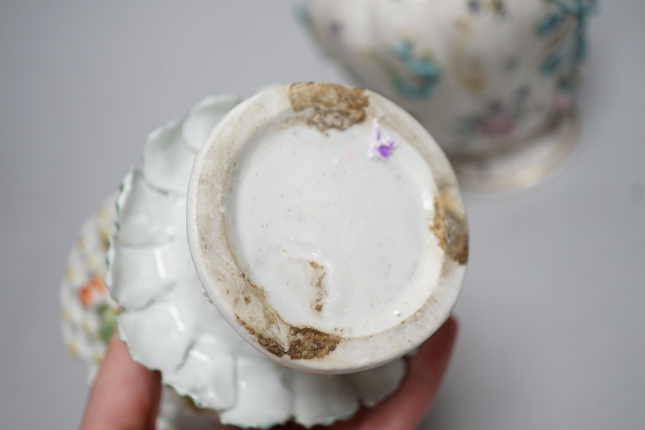 An 18th century Chelsea pot pourri vase, red anchor period, encrusted and painted with leaves and flowers and a Bow frill vase with mask heads encrusted with flowers. Tallest 16.5cm